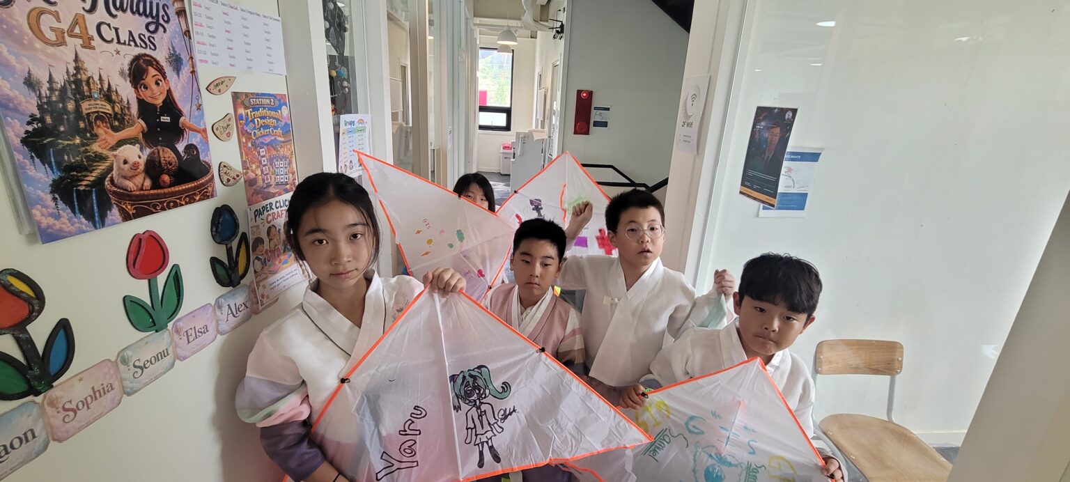Students holding up the kites they decorated